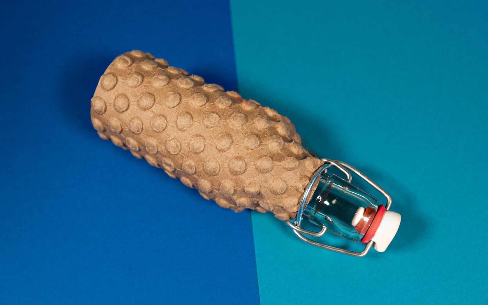 Glasflasche verpackt in PapairWrap der umweltschonenden Luftpolsterfolie aus Papier Glasflasche verpackt in PapairWrap der umweltschonenden Luftpolsterfolie aus Papier