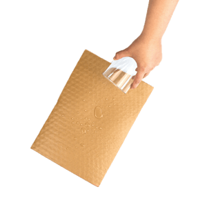 Eine Hand gießt Wasser auf PapairWrap Plus, die beschichtete Luftpolsterfolie aus Papier.