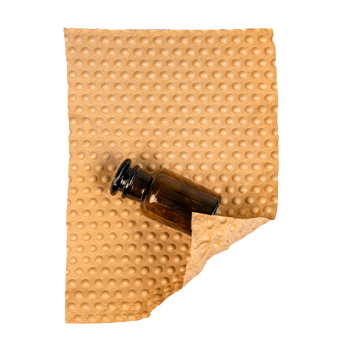 Eine kleine braune Flasche liegt halb eingewickelt in einem einlagigen PapairSheet.