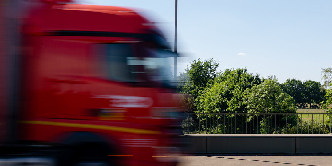 Fahrender Lastkraftwagen, LKW, auf Straße, unscharf von der schnellen Bewegung.
